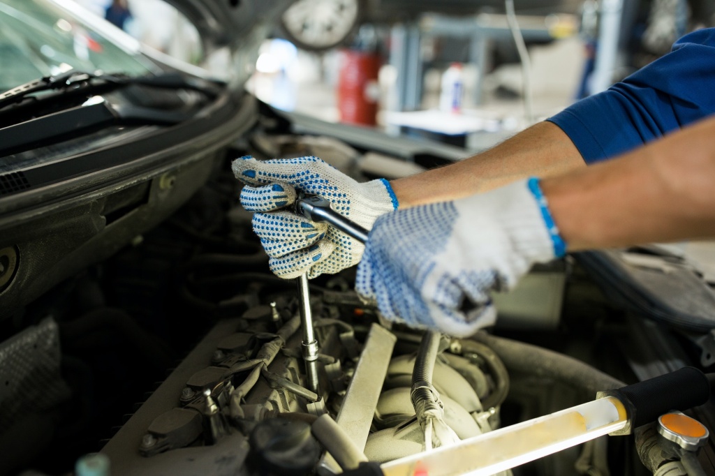 mechanic-man-with-wrench-repairing-car-at-workshop.jpg