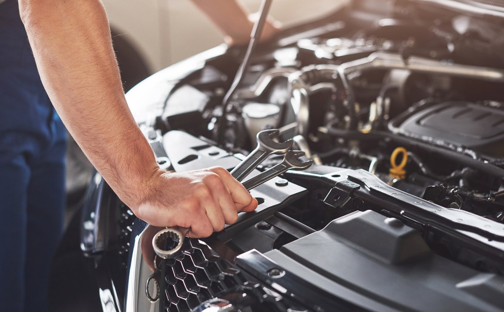 muscular-car-service-worker-repairing-vehicle.jpg